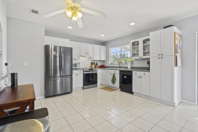 2008 SE Triumph Rd, Port Saint Lucie, FL 34952 - kitchen featuring stainless steel appliances, dark countertops, a sink, under cabinet range hood, and white cabinetry