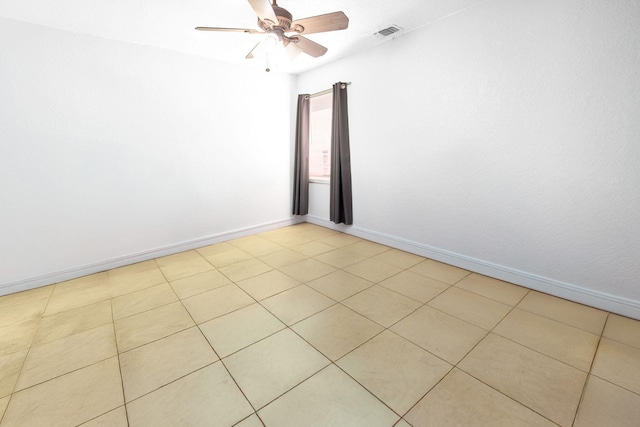 empty room featuring ceiling fan, baseboards, and light tile patterned flooring