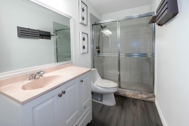 full bathroom featuring wood finished floors, a shower stall, toilet, and vanity