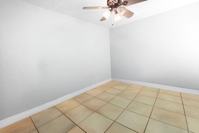unfurnished room featuring ceiling fan, light tile patterned flooring, and baseboards