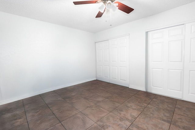 unfurnished bedroom with baseboards, a textured ceiling, ceiling fan, and tile patterned floors