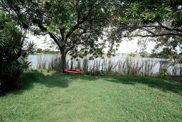 view of green lawn with a water view