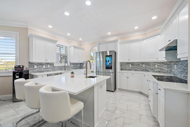9606 Shepard Pl, Wellington, FL 33414 - kitchen with light marble finish flooring, smart refrigerator, under cabinet range hood, a sink, and crown molding