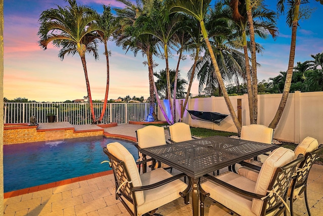 9606 Shepard Pl, Wellington, FL 33414 - pool at dusk with a patio area, a fenced backyard, and outdoor dining area