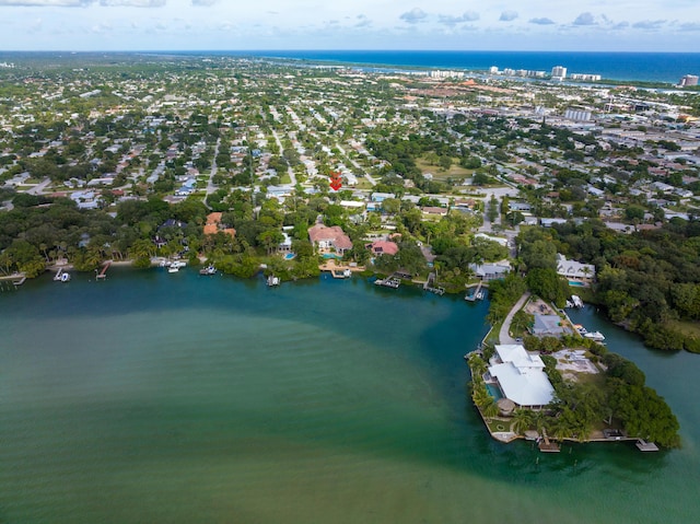 aerial view of property and surrounding area featuring a nearby body of water and nearby suburban area