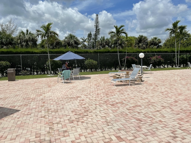 view of community with fence and a patio area