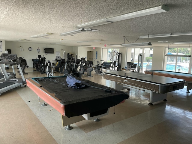 workout area featuring billiards, tile patterned floors, a textured ceiling, and plenty of natural light