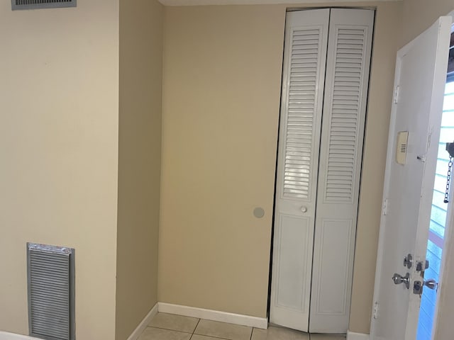 hallway with light tile patterned flooring and baseboards