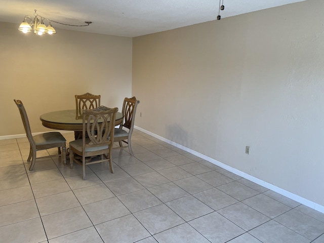 dining area featuring a chandelier, light tile patterned floors, and baseboards