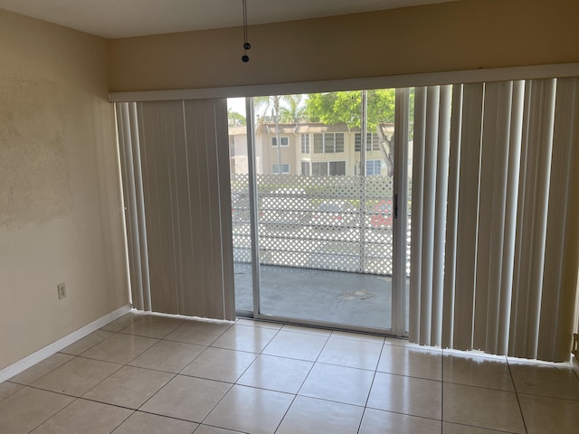 unfurnished dining area featuring light tile patterned floors and baseboards