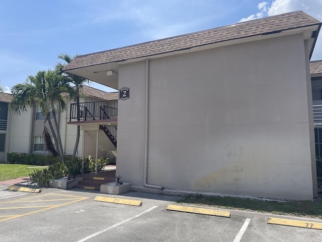 view of building exterior featuring uncovered parking and stairway
