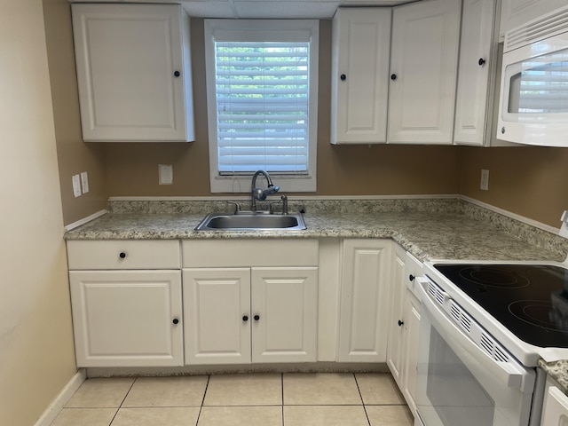 kitchen featuring white appliances, a sink, white cabinets, light tile patterned flooring, and light countertops