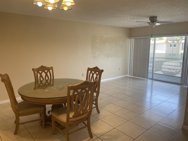 dining room with a chandelier, a ceiling fan, baseboards, and light tile patterned flooring