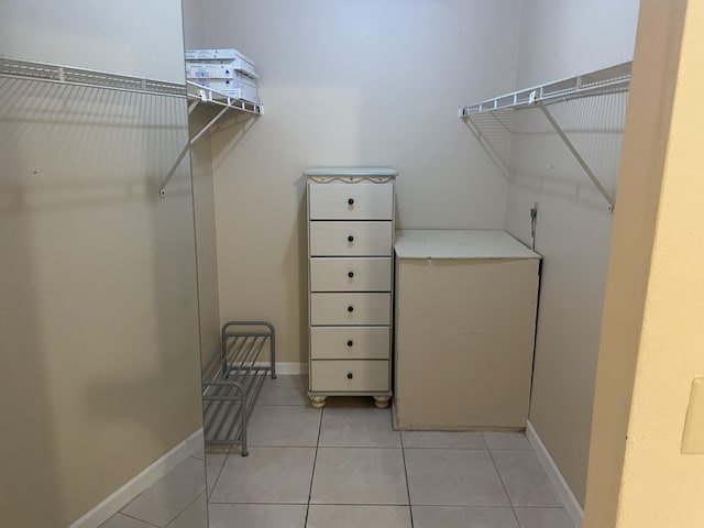 walk in closet with light tile patterned floors
