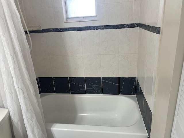 bathroom featuring toilet and shower / bathtub combination with curtain