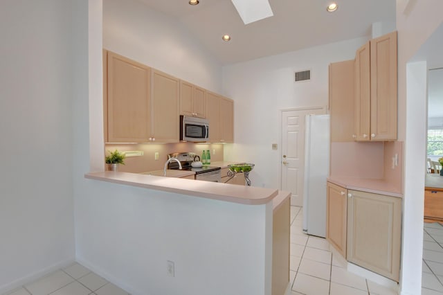 17215 Boca Club Blvd Unit 2, Boca Raton, FL 33487 - kitchen featuring stainless steel microwave, range with electric cooktop, a skylight, light brown cabinets, and light countertops