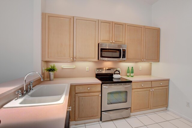 17215 Boca Club Blvd Unit 2, Boca Raton, FL 33487 - kitchen with appliances with stainless steel finishes, light brown cabinets, a sink, light countertops, and light tile patterned floors