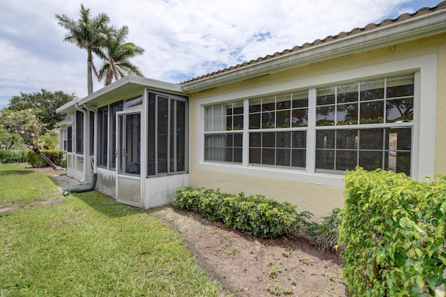 17215 Boca Club Blvd Unit 2, Boca Raton, FL 33487 - back of house featuring a sunroom, stucco siding, and a lawn