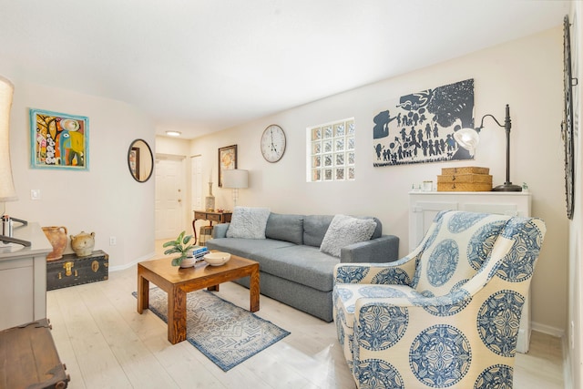 living area featuring baseboards and light wood-style flooring