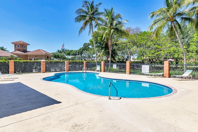 community pool with fence and a patio area
