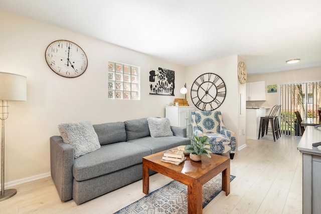 living area with light wood-style flooring and baseboards