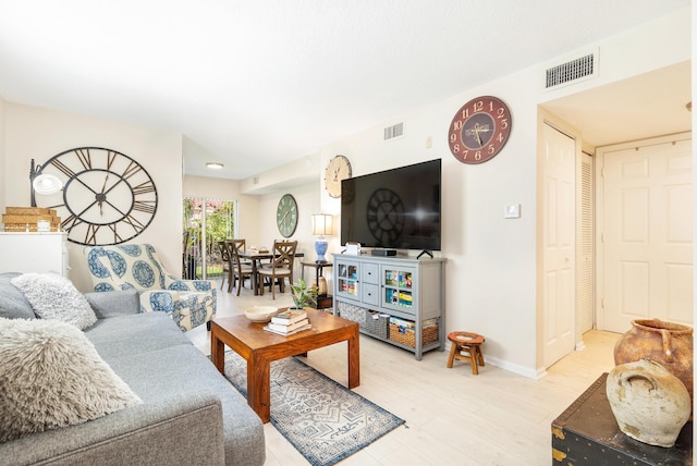 living area featuring light wood finished floors and baseboards
