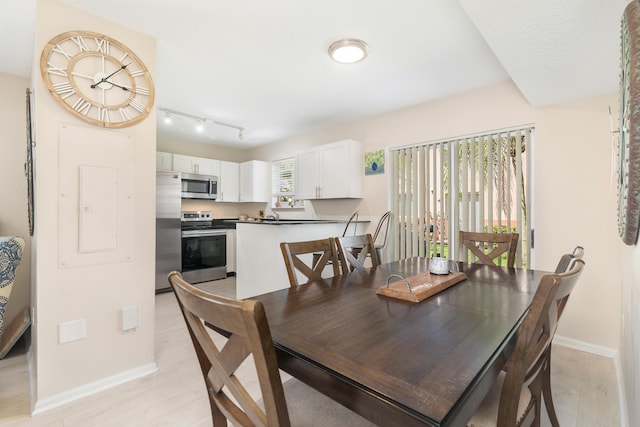 dining area with baseboards and light wood finished floors