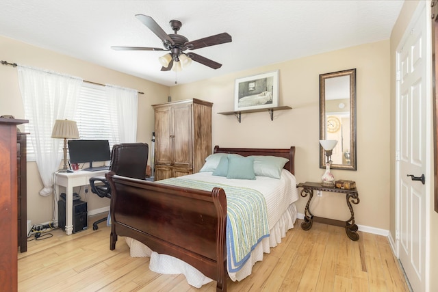 bedroom featuring hardwood / wood-style flooring, baseboards, a ceiling fan, and an office area