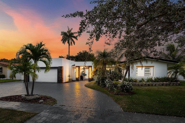 2611 NE 49th St, Lighthouse Point, FL 33064 - view of front of house featuring stucco siding, decorative driveway, a garage, and a front yard