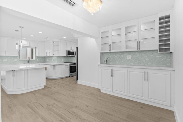 2611 NE 49th St, Lighthouse Point, FL 33064 - kitchen featuring stainless steel appliances, light countertops, decorative backsplash, light wood finished floors, and recessed lighting