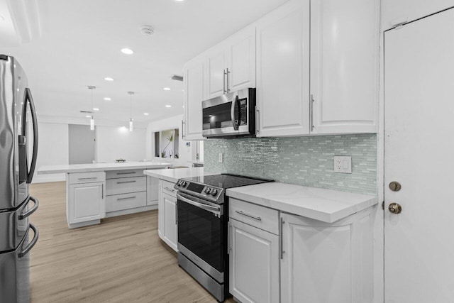 2611 NE 49th St, Lighthouse Point, FL 33064 - kitchen featuring appliances with stainless steel finishes, white cabinetry, light wood-style flooring, decorative backsplash, and recessed lighting