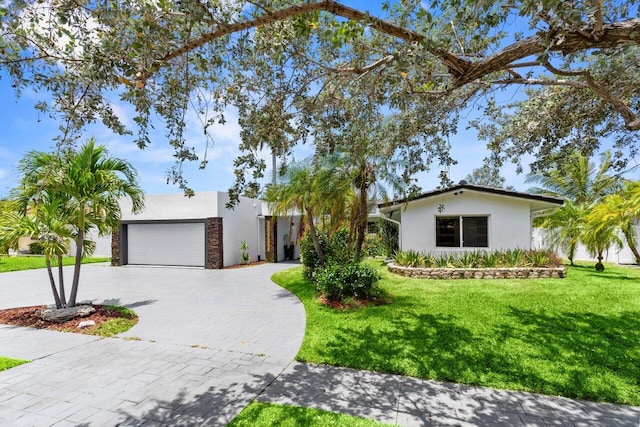 2611 NE 49th St, Lighthouse Point, FL 33064 - view of front of house featuring stucco siding, decorative driveway, and a front yard