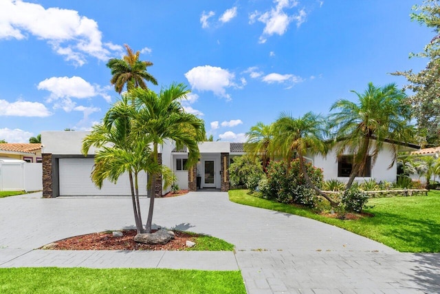 2611 NE 49th St, Lighthouse Point, FL 33064 - view of front facade featuring decorative driveway, stucco siding, a front yard, and a garage