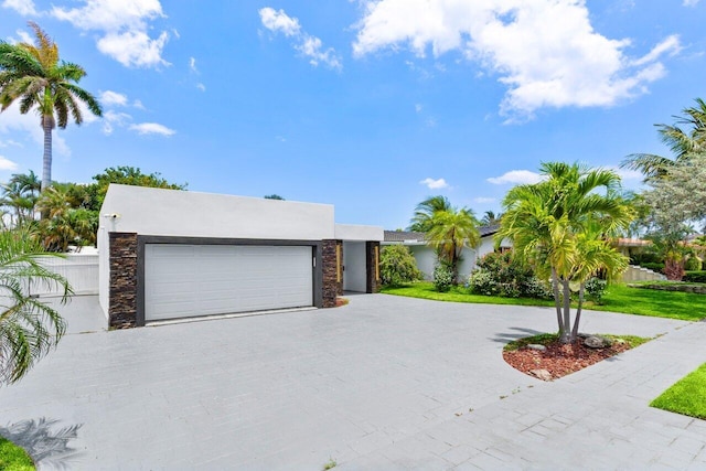 2611 NE 49th St, Lighthouse Point, FL 33064 - contemporary home with decorative driveway, a garage, and stucco siding