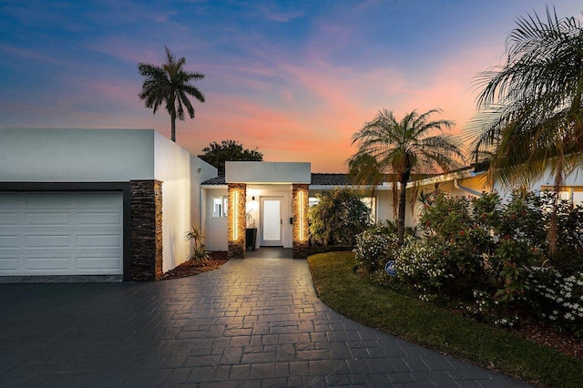2611 NE 49th St, Lighthouse Point, FL 33064 - modern home with stucco siding, stone siding, decorative driveway, and an attached garage