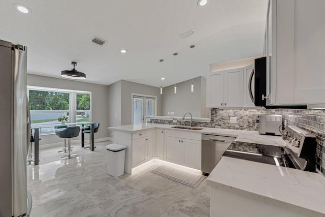 11849 59th St N, Royal Palm Beach, FL 33411 - kitchen with stainless steel appliances, a peninsula, a sink, backsplash, and recessed lighting