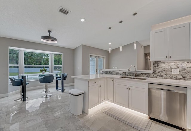 11849 59th St N, Royal Palm Beach, FL 33411 - kitchen featuring dishwasher, a sink, a peninsula, backsplash, and light stone counters