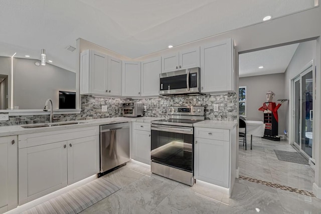 11849 59th St N, Royal Palm Beach, FL 33411 - kitchen featuring stainless steel appliances, a sink, decorative backsplash, light marble finish flooring, and white cabinets