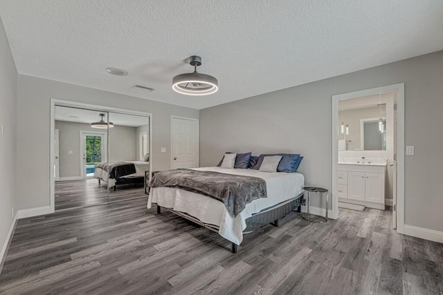 11849 59th St N, Royal Palm Beach, FL 33411 - bedroom with wood finished floors, baseboards, a textured ceiling, a closet, and ensuite bath