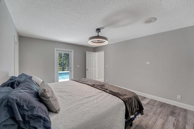 11849 59th St N, Royal Palm Beach, FL 33411 - bedroom featuring wood finished floors, a textured ceiling, access to exterior, baseboards, and a ceiling fan