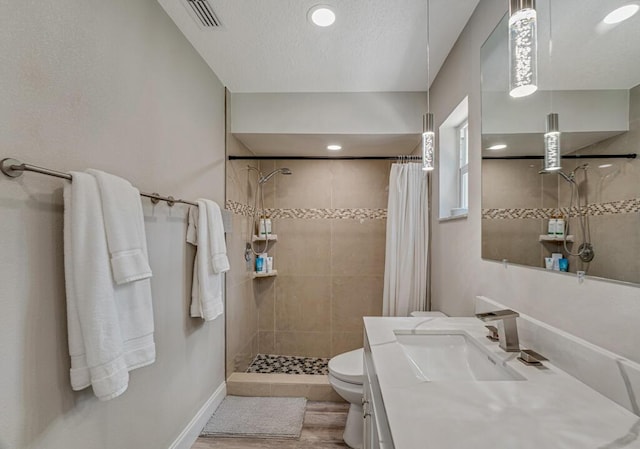 11849 59th St N, Royal Palm Beach, FL 33411 - bathroom featuring tiled shower, toilet, wood finished floors, vanity, and baseboards
