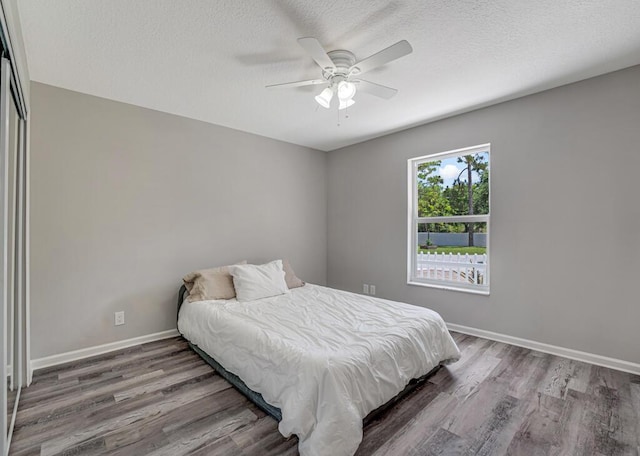11849 59th St N, Royal Palm Beach, FL 33411 - bedroom featuring wood finished floors, baseboards, a textured ceiling, and ceiling fan