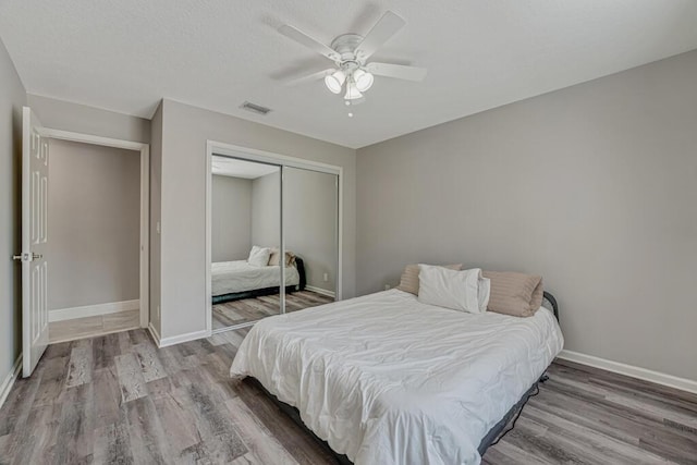 11849 59th St N, Royal Palm Beach, FL 33411 - bedroom featuring wood finished floors, a closet, baseboards, and a ceiling fan