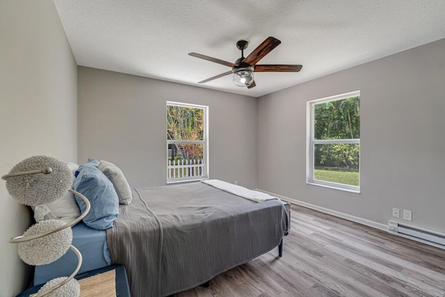 11849 59th St N, Royal Palm Beach, FL 33411 - bedroom with multiple windows, wood finished floors, a textured ceiling, baseboards, and a ceiling fan