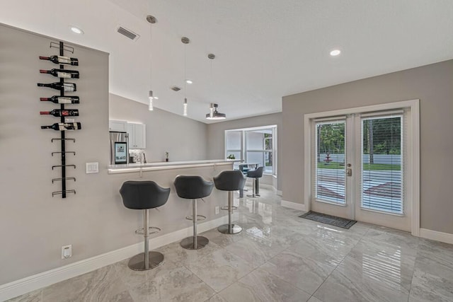 11849 59th St N, Royal Palm Beach, FL 33411 - kitchen featuring baseboards, light marble finish floors, smart refrigerator, a kitchen bar, and french doors
