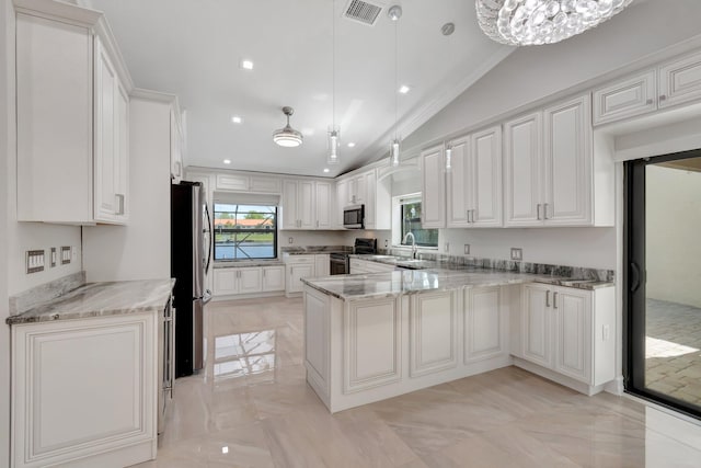 3 Independence Ct, Deerfield Beach, FL 33442 - kitchen featuring appliances with stainless steel finishes, lofted ceiling, a peninsula, light stone countertops, and a sink