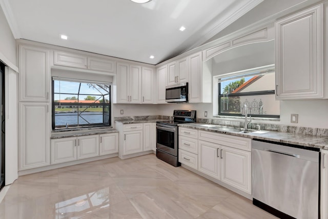 3 Independence Ct, Deerfield Beach, FL 33442 - kitchen featuring appliances with stainless steel finishes, a sink, light stone countertops, plenty of natural light, and lofted ceiling
