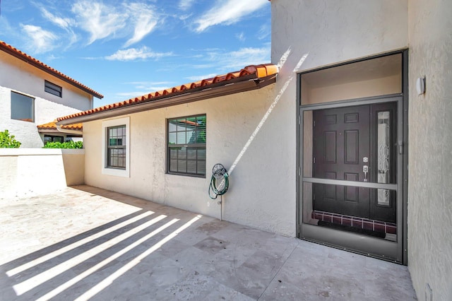 3 Independence Ct, Deerfield Beach, FL 33442 - property entrance with stucco siding, a patio area, and a tiled roof