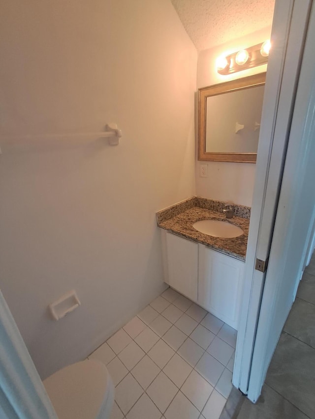 4964 Palmbrooke Cir, West Palm Beach, FL 33417 - half bathroom featuring vanity, tile patterned flooring, toilet, and a textured ceiling