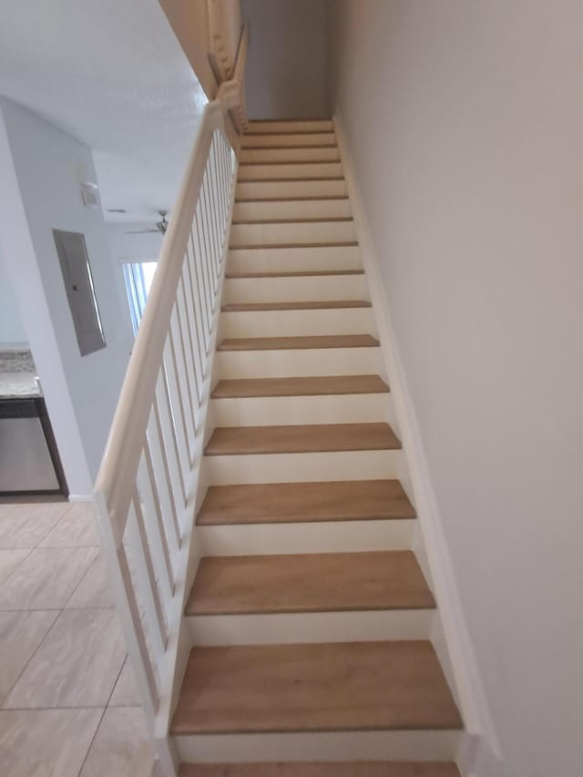 4964 Palmbrooke Cir, West Palm Beach, FL 33417 - stairway featuring electric panel, tile patterned floors, and ceiling fan